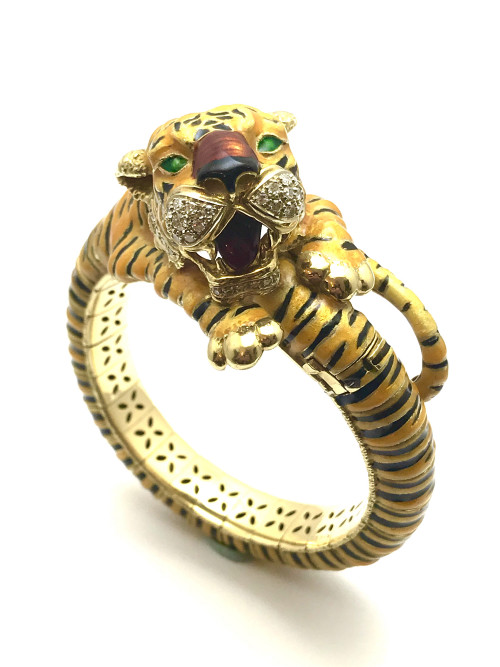 Cartier diamond and enamel 18 karat yellow gold bangle tiger bracelet. The tiger’s mouth and jowls are adorned with 34 single cut round diamonds weighing approximately 0.45 carats. The bracelet is all 18 kt., applied with yellow/orange enamel. To know more details please visit here https://eyeonjewels.com/product/cartier-diamond-and-enamel-yellow-gold-bangle-tiger-bracelet-14048