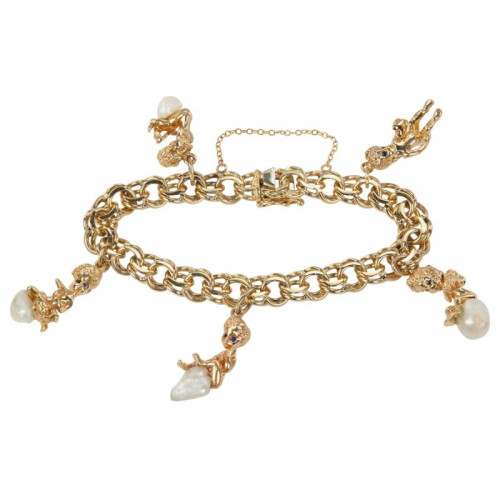 A Ruser 14 karat yellow gold charm bracelet. This link bracele tfeatures 5 charms that dangle from the bracelet with Rusers babies that have sapphire eyes sitting on pearls Circa 1970s. The bracelet is approximately 7 inches in diameter. The chain link bracelet is approximately 037 inches in width. To buy this product please visit here https://eyeonjewels.com/product/ruser-gold-and-pearl-charm-bracelet-12282